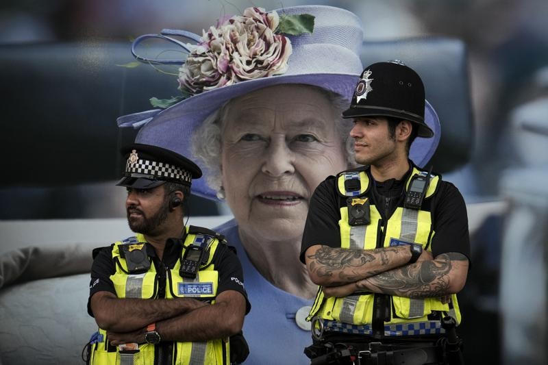 Các nhân viên cảnh sát làm nhiệm vụ trước một bức ảnh của Nữ hoàng Elizabeth II ở London.
