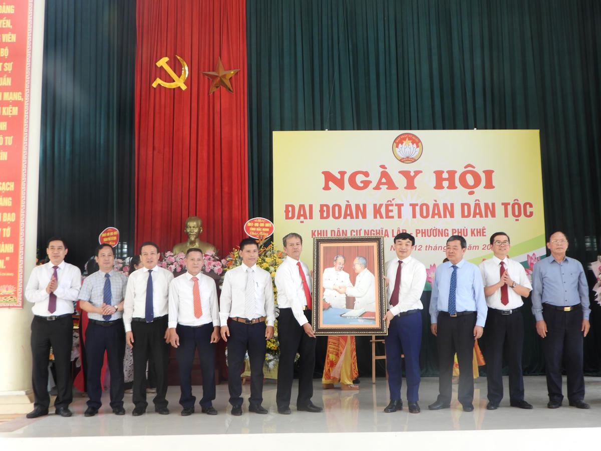 Chủ tịch Ủy ban MTTQ tỉnh Bắc Ninh Nguyễn Đình Lợi trao tặng bức ảnh "Bác Hồ - Bác Tôn" cho khu phố Nghĩa Lập.