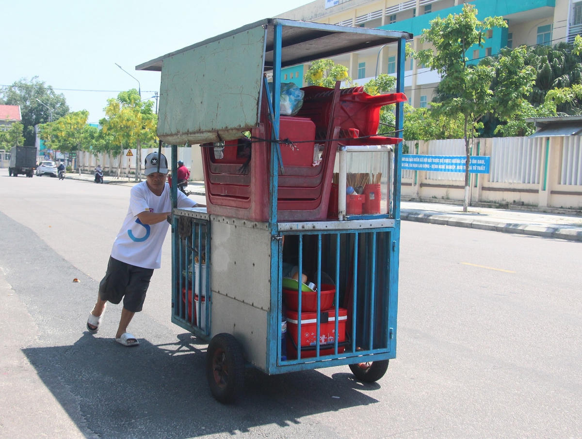 Người dân đẩy xe hàng trên đường Lê Lợi, TP Tam Kỳ.