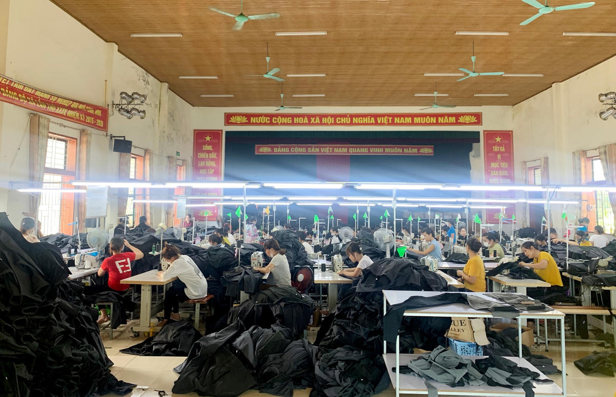 Phía trong hội trường hàng chục công nhân đang miệt mài sản xuất. Ảnh: Cẩm Kỳ.