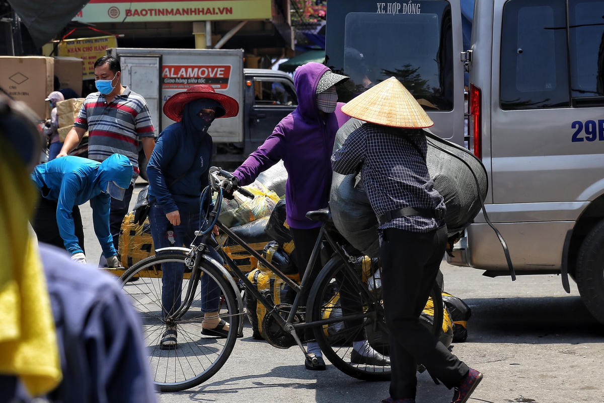 Theo ghi nhận của PV Báo Đại Đoàn Kết, tại chợ Đồng Xuân (Hà Nội) lúc 12h trưa ngày 18/5, vẫn có hàng chục người dân đang tất tả bốc vác hàng hóa thuê dưới thời tiết nắng nóng như "đổ lửa".