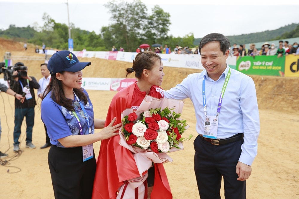 Lãnh đạo tỉnh Hoà Bình tặng hoa chúc mừng VĐV Đinh Thị Như Quỳnh khi cô về đích. (Ảnh: Trọng Đạt/TTXVN).