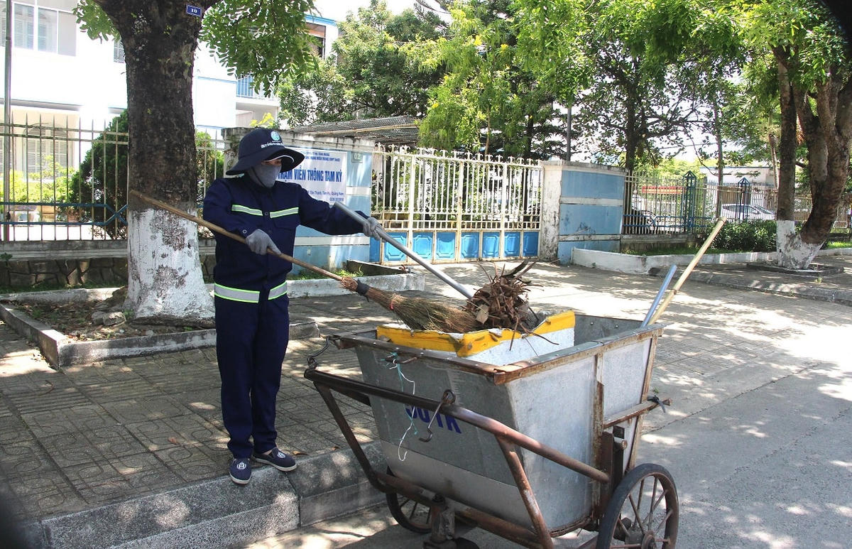 Công nhân đưa rác lên xe ở đường Trần Hưng Đạo.