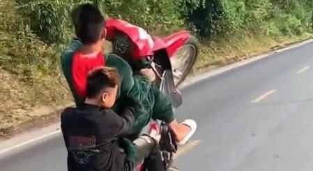 Hình ảnh nhóm thanh niên đi xe máy bốc đầu, gây nguy hiểm cho người tham gia giao thông.