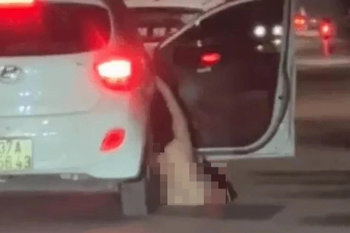 Hình ảnh người phụ nữ không mặc quần áo rơi từ ô tô xuống đường (Ảnh cắt từ clip).