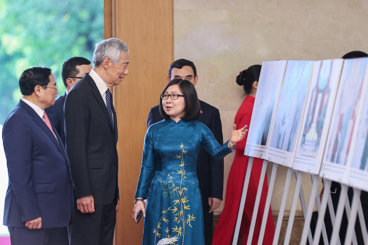 Thủ tướng Phạm Minh Chính và Thủ tướng Singapore Lý Hiển Long xem trưng bày ảnh về quan hệ hợp tác giữa Việt Nam và Singapore. Ảnh: VGP/Nhật Bắc.