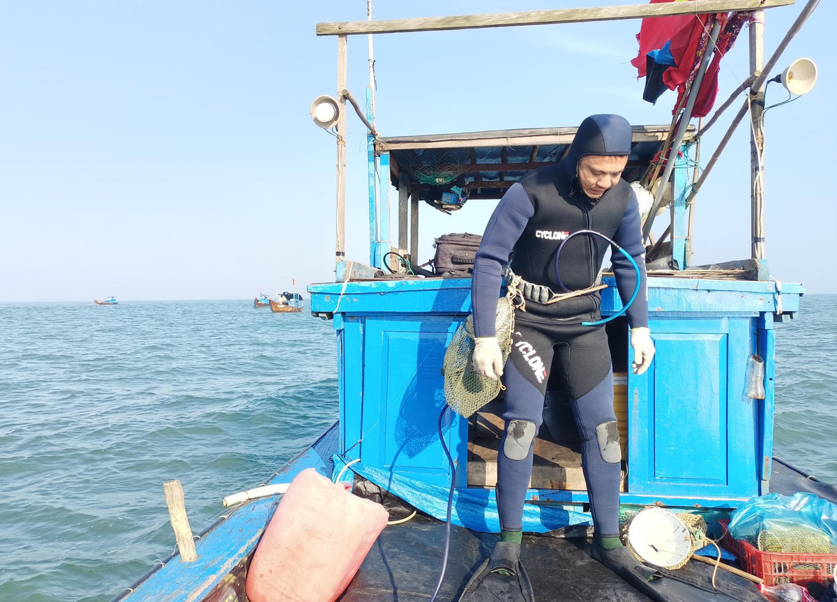 Anh Ngô Thanh Đấu chuẩn bị lặn xuống biển bắt tôm nhí.