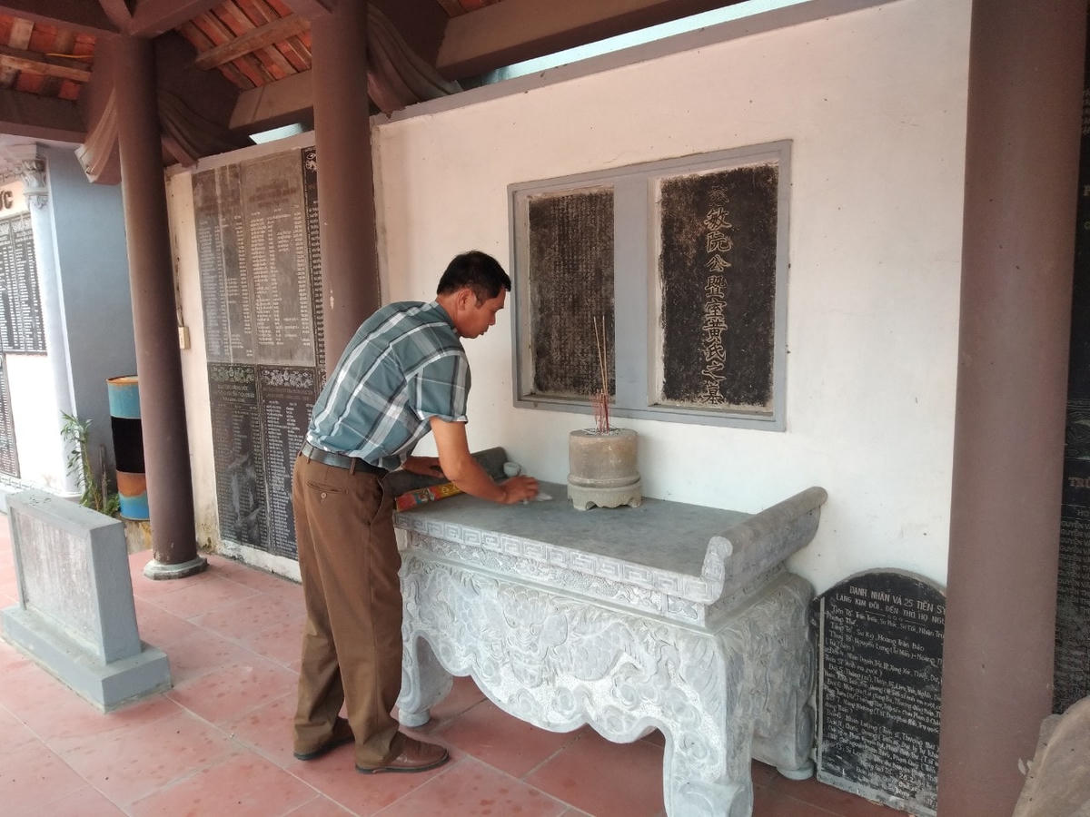 Ông Nguyễn Văn Điết, trưởng họ, đời thứ 19 họ Nguyễn làng Kim Đôi chăm chút tấm bia của dòng tộc họ Nguyễn.