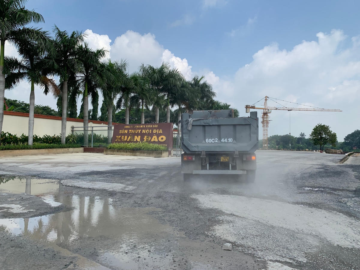 Một chiếc xe ben vào cảng thủy nội địa để trả hàng kéo theo bụi bẩn mù mịt. Ảnh: Mạnh Thìn.