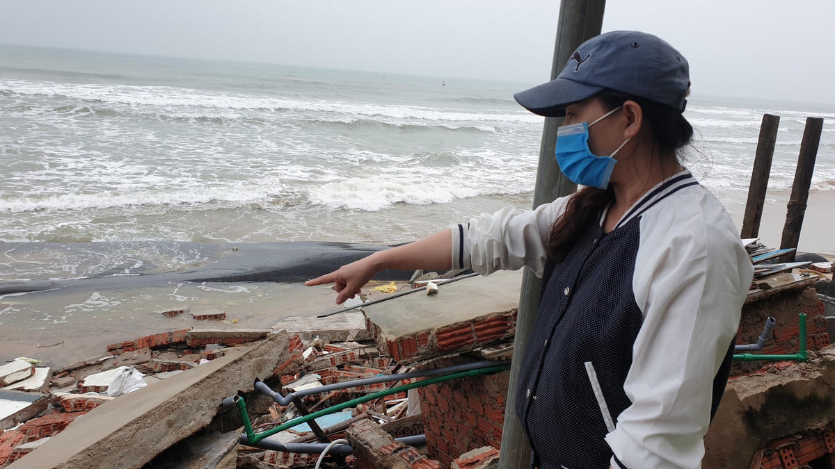 Chị Nguyễn Thị Hường chỉ ngôi nhà bị sóng biển đánh sập.