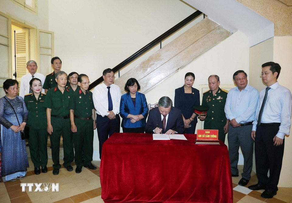 Tổng Bí thư Tô Lâm viết sổ lưu niệm tại Di tích Nhà số 48 Hàng Ngang. (Ảnh: Thống Nhất/TTXVN)