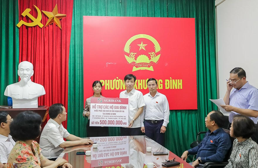 Ông Phạm Đức Ấn – Bí thư Đảng ủy, Chủ tịch HĐTV  (phía ngoài bên phải) và đ/c Phạm Đức Tuấn – Thành viên HĐTV, Chủ tịch Công đoàn Agribank (ở giữa) trao hỗ trợ các gia đình bị nạn..