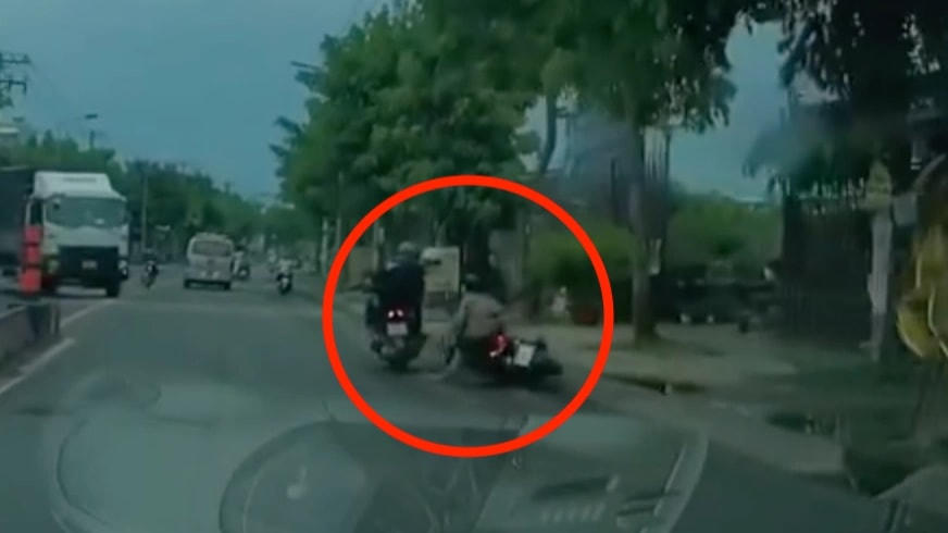 Cô gái bị cướp điện thoại, ngã xuống đường (Ảnh cắt từ clip).