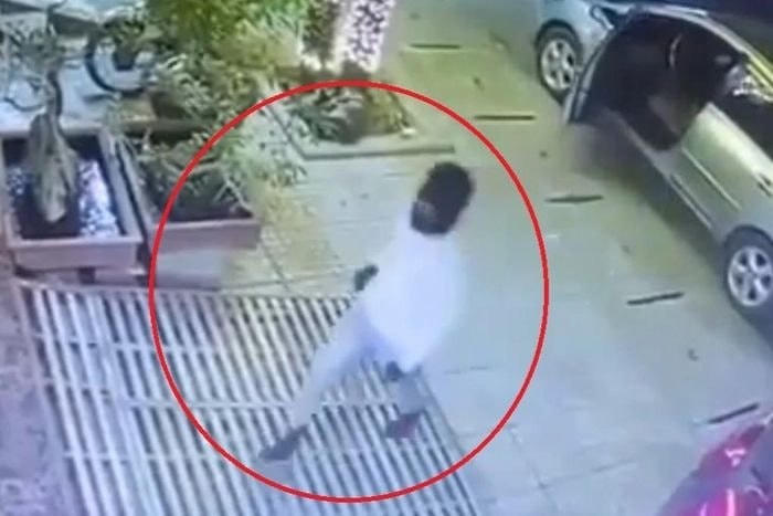 Người đàn ông trên cầm búa đi vào cửa tiệm rồi bất ngờ đập vỡ kính, lấy đi một số vàng và bỏ chạy. Ảnh: Camera an ninh ghi lại.