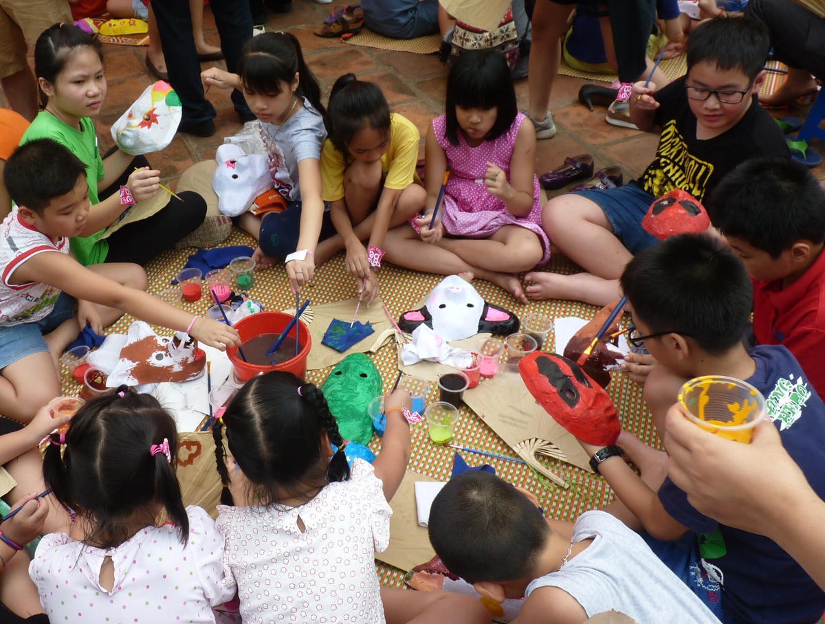 Trẻ em say sưa trải nghiệm vẽ mặt nạ giấy.  