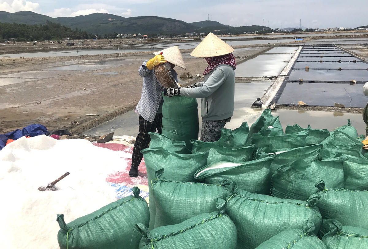 Ngư dân đang cho muối vào bao để đem đi bán.