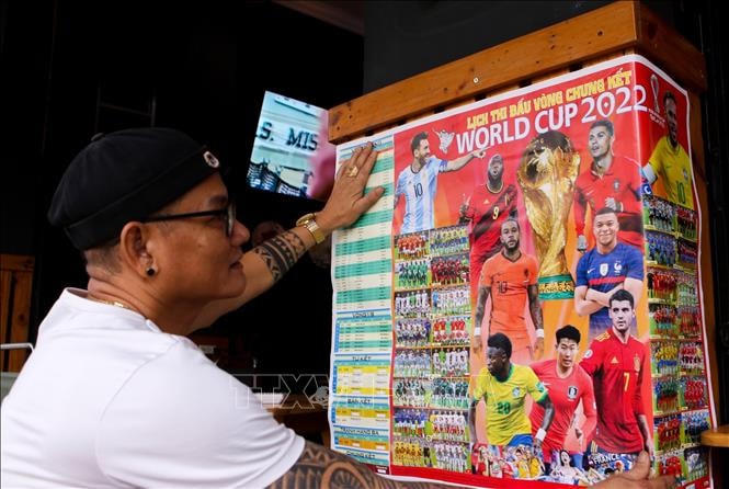 Lịch thi đấu World Cup 2022 được dán ngay trước các quán cà phê. Ảnh: Trần Lê Lâm/TTXVN