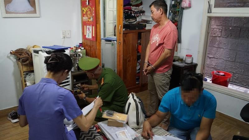 Công an và đại diện Viện Kiểm sát thực hiện khám xét nơi ở của Nguyễn Nho Cầm. Ảnh: Công an Đà Nẵng.