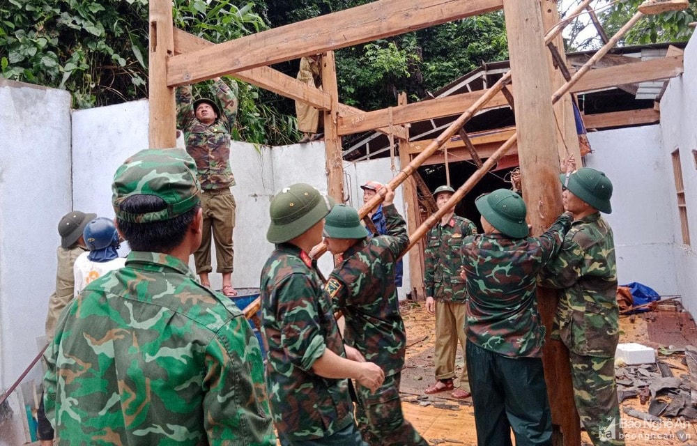 Cán bộ, chiến sĩ huyện Kỳ Sơn giúp người dân bản Huồi Thợ, xã Hữu Kiệm (Nghệ An) tháo dỡ ngôi nhà bị sạt lở do hoàn lưu bão số 4. Ảnh: Hoàng Anh.