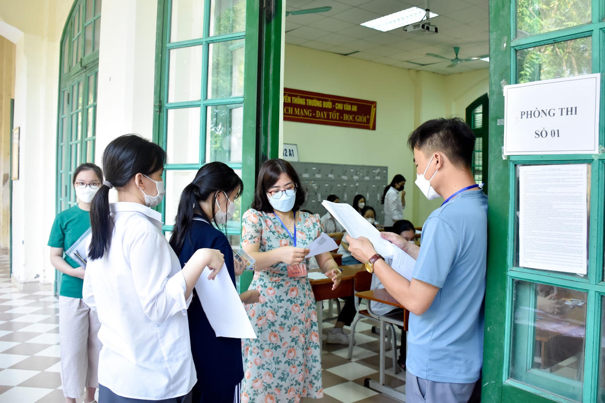 Cán bộ coi thi kiểm tra thông tin thí sinh tại điểm thi Trường THPT Chu Văn An.