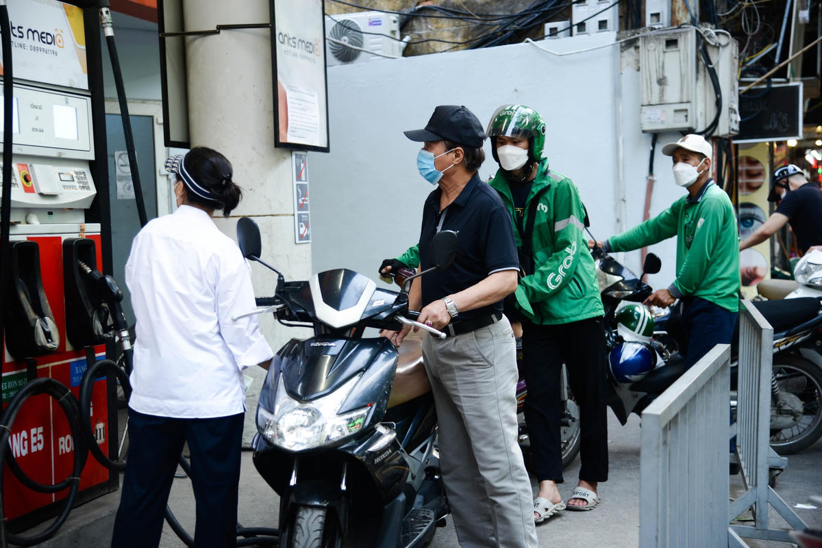 Tại cây xăng trên đường Khâm Thiên, nhân viên phải hoạt động liên tục để kịp phục vụ cho dòng người đổ xăng nối đuôi nhau liên tiếp.