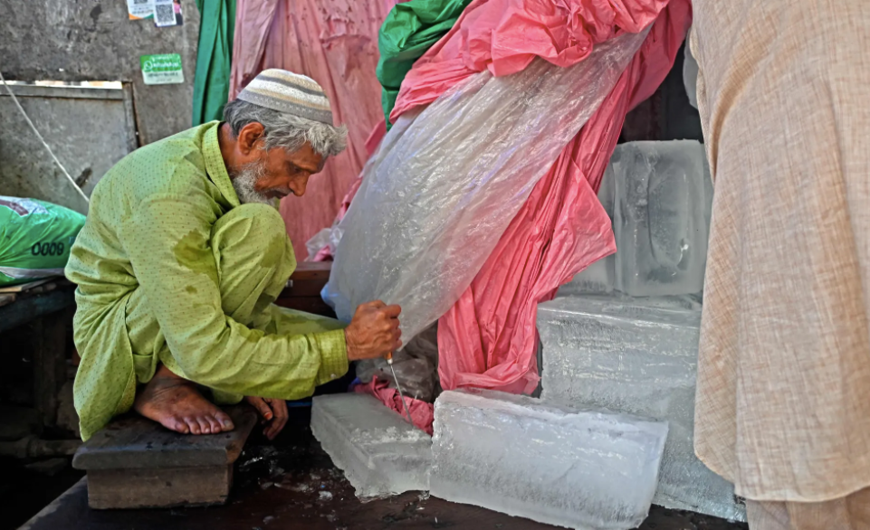 Một người bán hàng đang đập vỡ một phiến đá để bán. Ảnh: Sajjad Hussain / AFP / Getty Images.