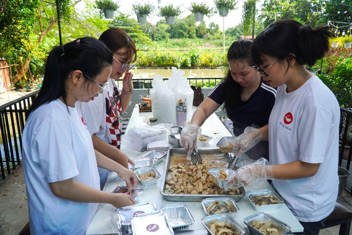 Các bạn sinh viên chia thức ăn vào hộp.
