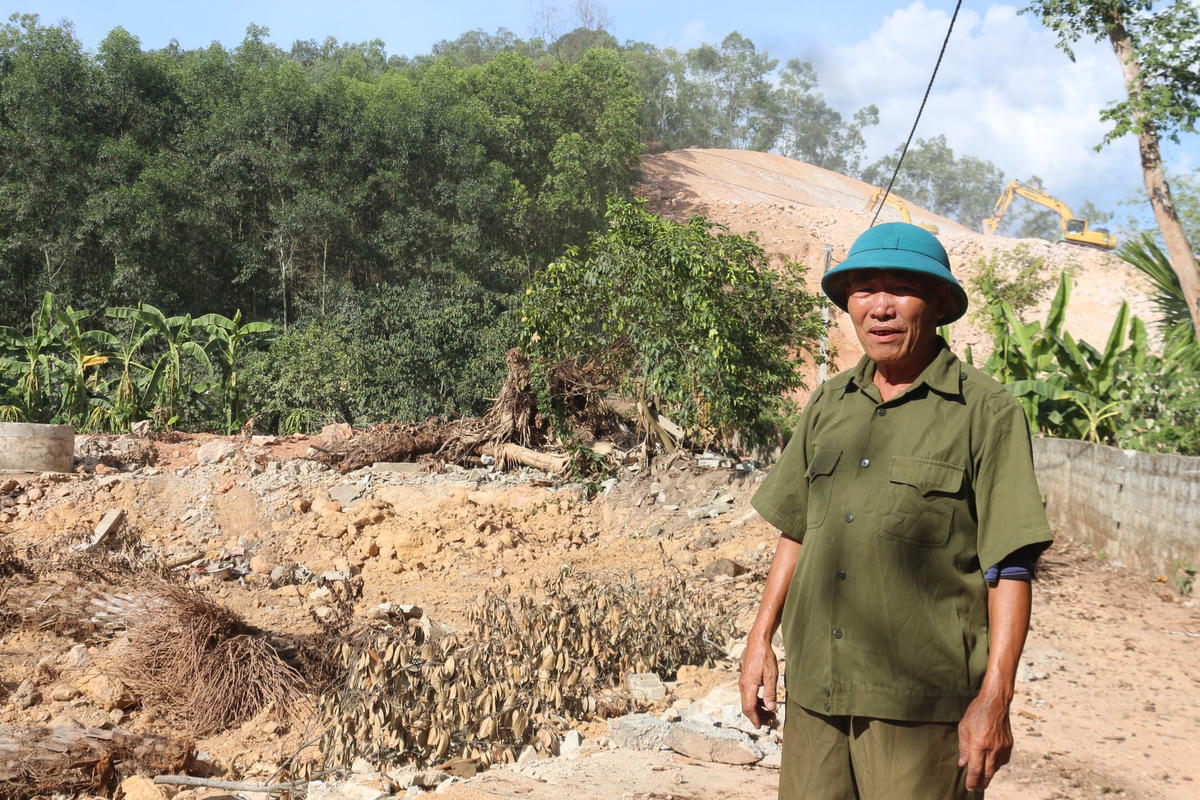 Thương binh Đặng Công Ất bên nền ngôi nhà cũ đã tháo dỡ để nhường đất cho Dự án cao tốc đường bộ Bắc - Nam.