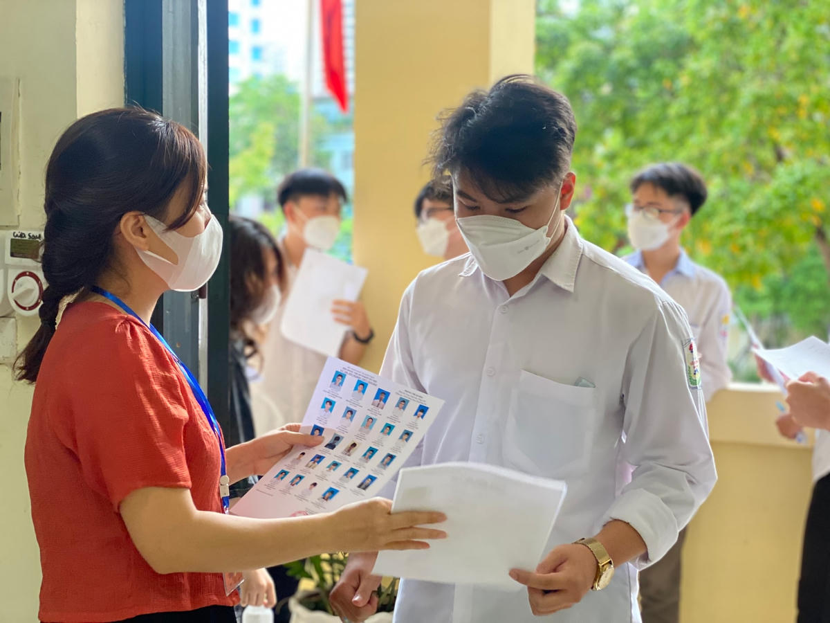 Cán bộ coi thi kiểm tra thông tin thí sinh trước khi vào phòng thi tốt nghiệp THPT năm 2022. 