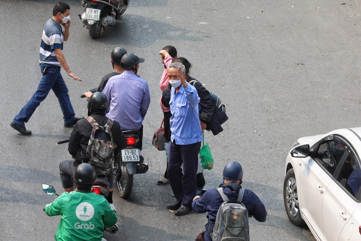 Người đàn ông giơ tay để xin qua đường.