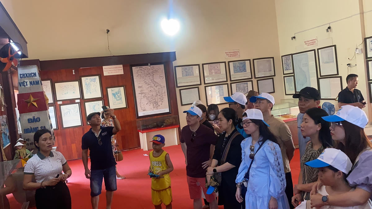 Du khách nghe hướng dẫn viên nói về lịch sử văn hóa ở đảo Lý Sơn.