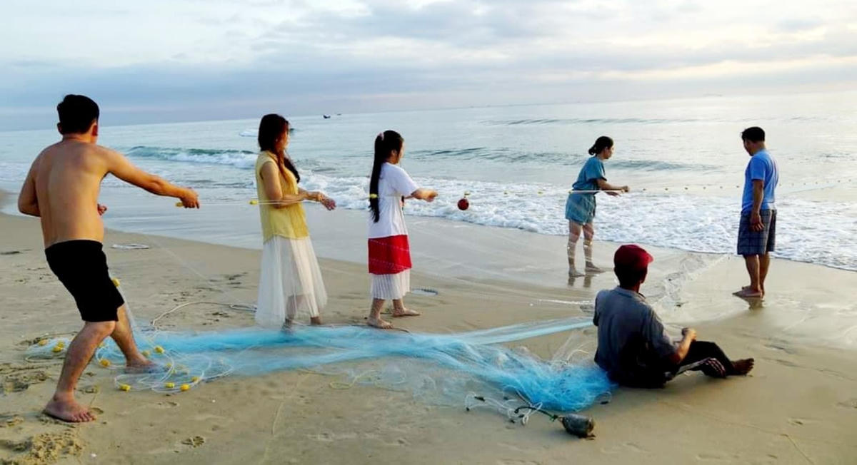 Du khách tham gia trải nghiệm kéo lưới tại bãi biển Tam Thanh.