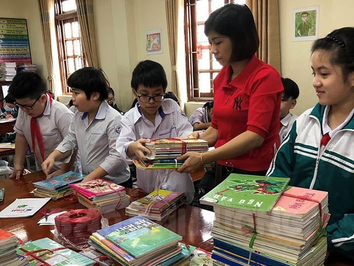 Giáo viên và học sinh Hải Dương phân loại sách giáo khoa để ủng hộ học sinh vùng bão lũ.        Ảnh: TL.