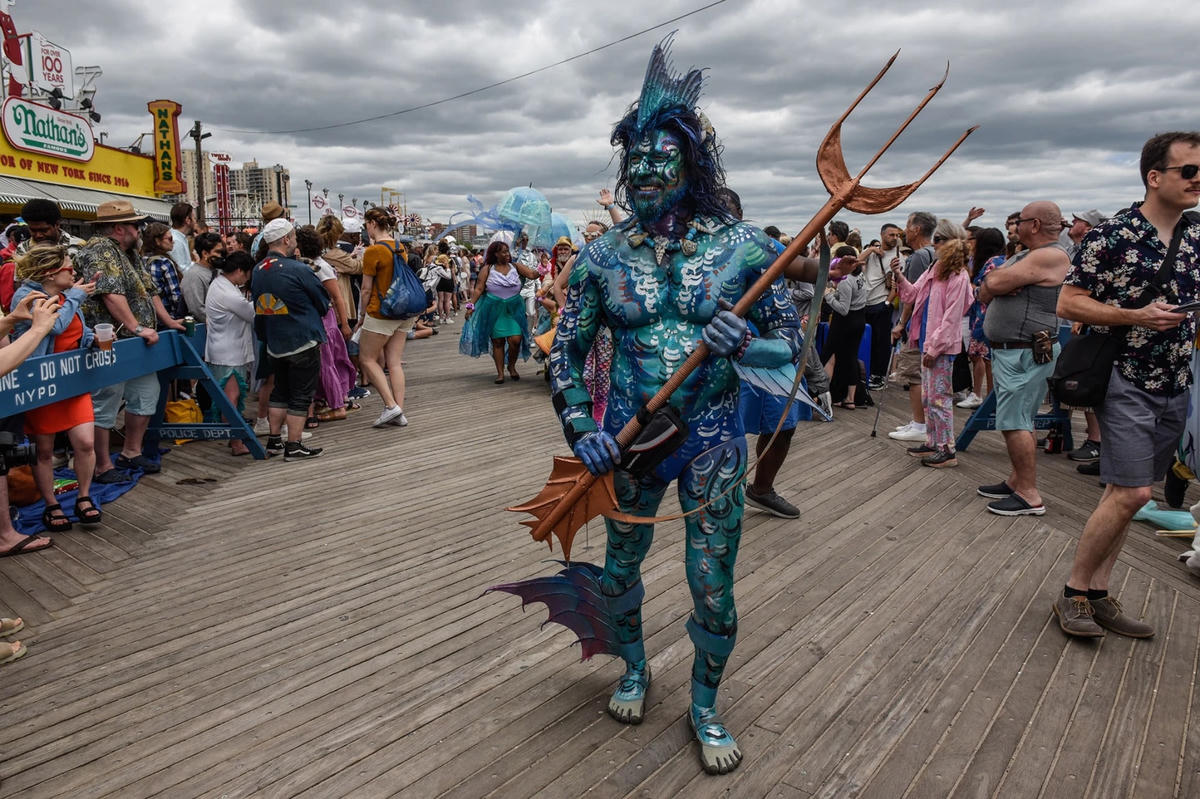 Một người đàn ông hóa trang thành địch thủ của Aquaman trên lối đi bộ lót ván ở Coney Island.