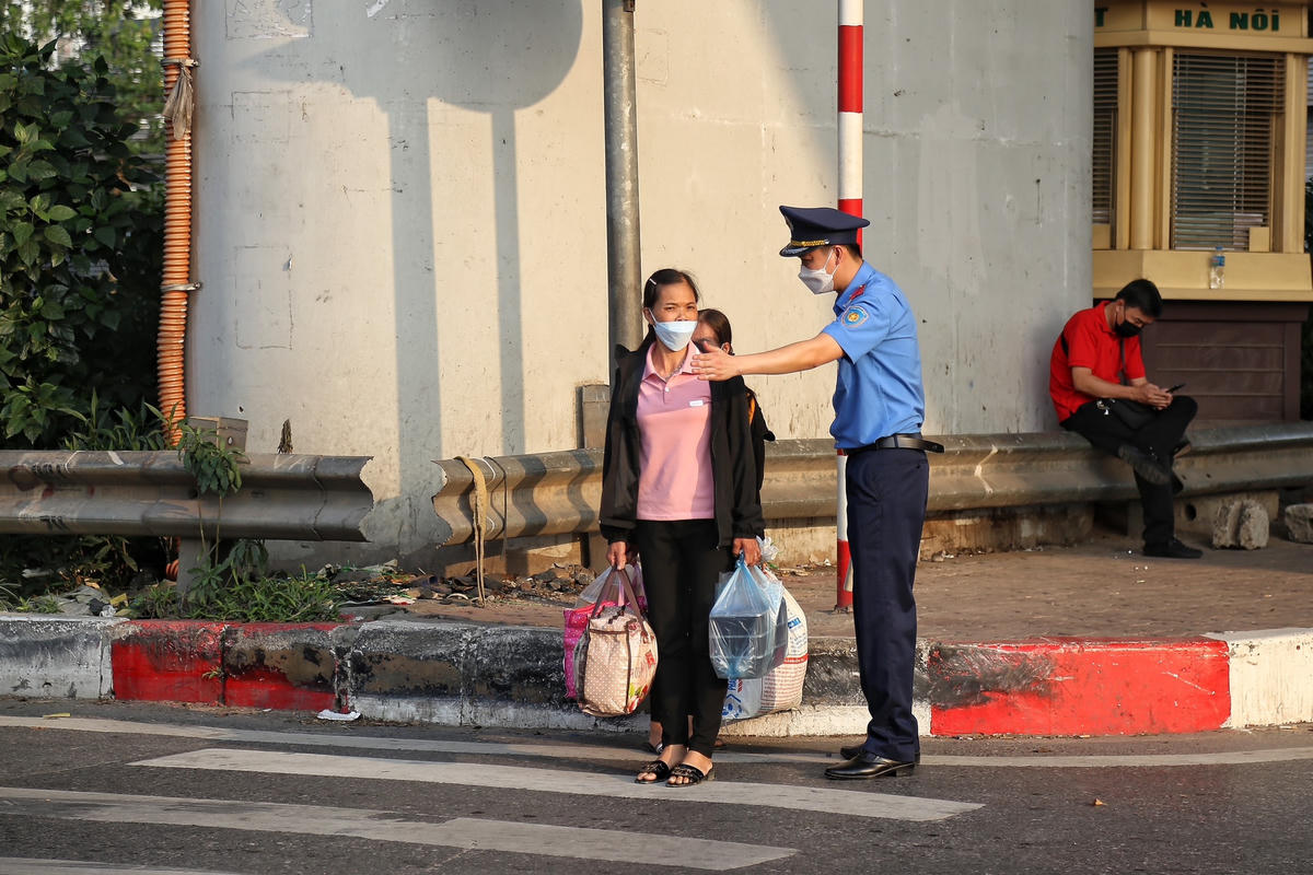 Lực lượng Thanh tra giao thông hỗ trợ người dân qua đường.