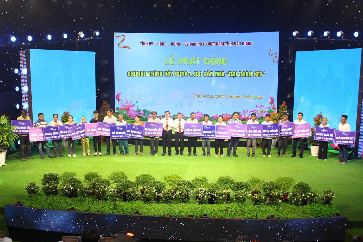 Lãnh đạo tỉnh Hậu Giang trao tặng bản tượng trưng nhà “Đại đoàn kết”. (Ảnh: Trường Sơn)