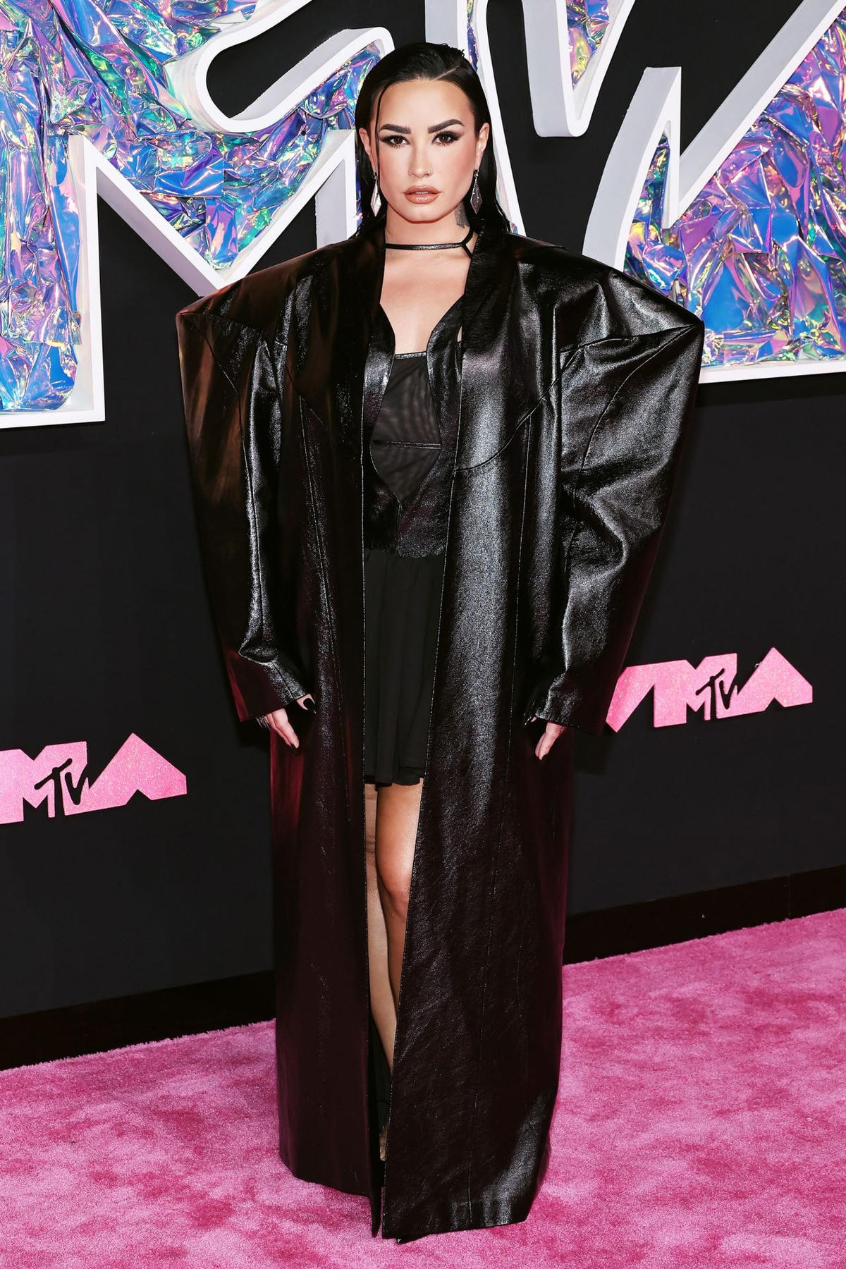 Demi Lovato trông sắc sảo trong chiếc áo khoác hình khối màu đen cỡ lớn kết hợp với chiếc váy ngắn bằng da và lưới của thương hiệu Buerlangma mới nổi của Trung Quốc.