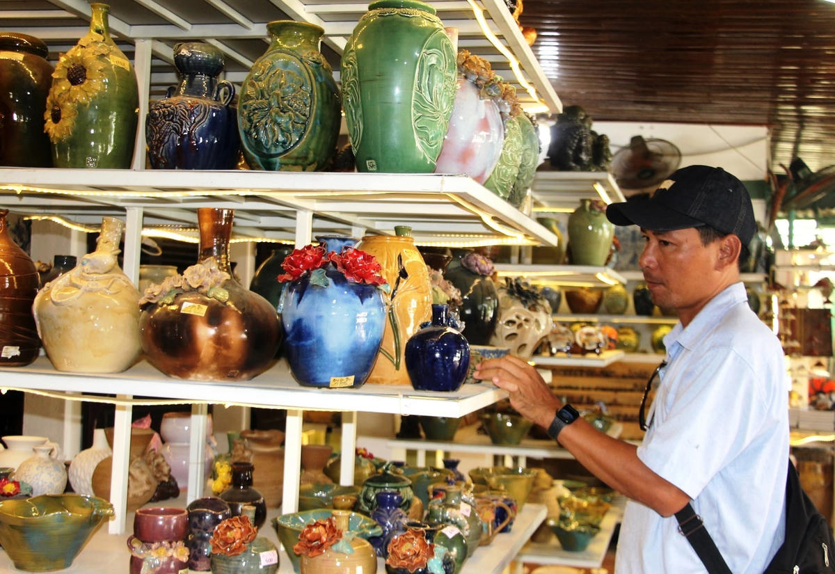 Du khách tham quan một cơ sở với nhiều sản phẩm ở làng gốm Thanh Hà.