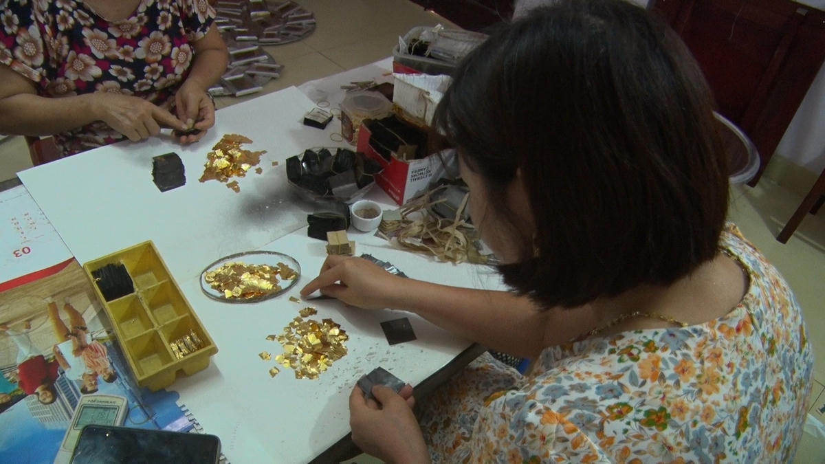 Những người thợ thủ công đang xếp từng lá vàng được đánh thật mỏng.