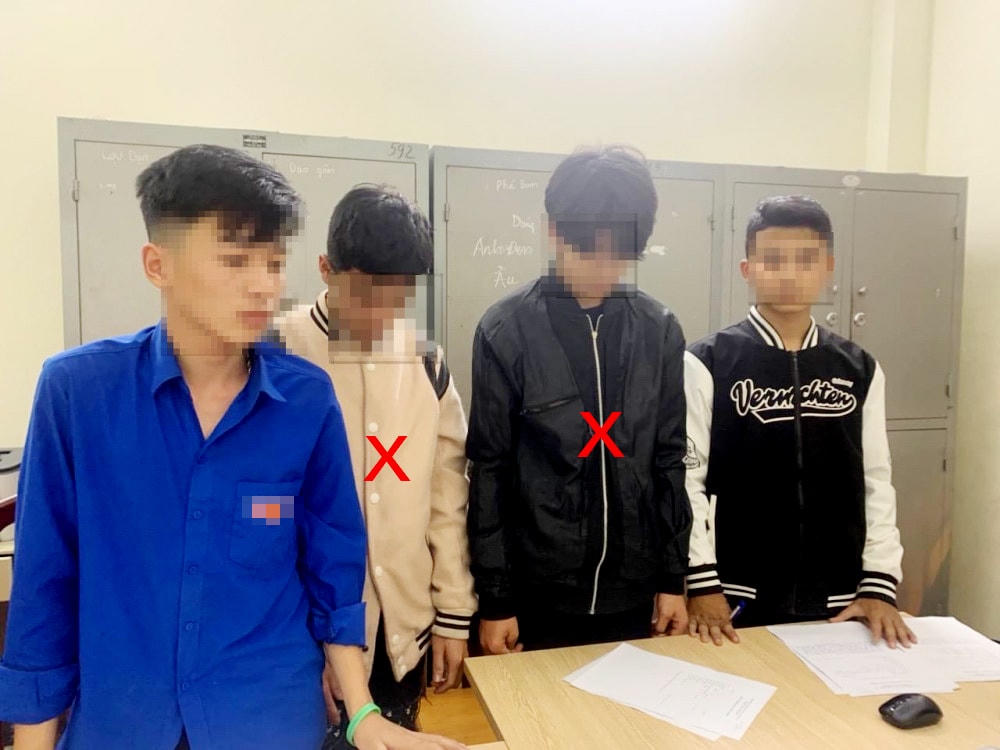 Hai đối tượng (x ở giữa) tại cơ quan công an.