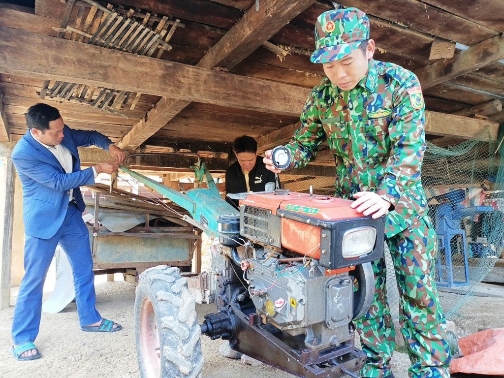 Bộ đội Biên phòng Việt Nam giúp đỡ người dân sửa chữa máy móc nông cụ.  