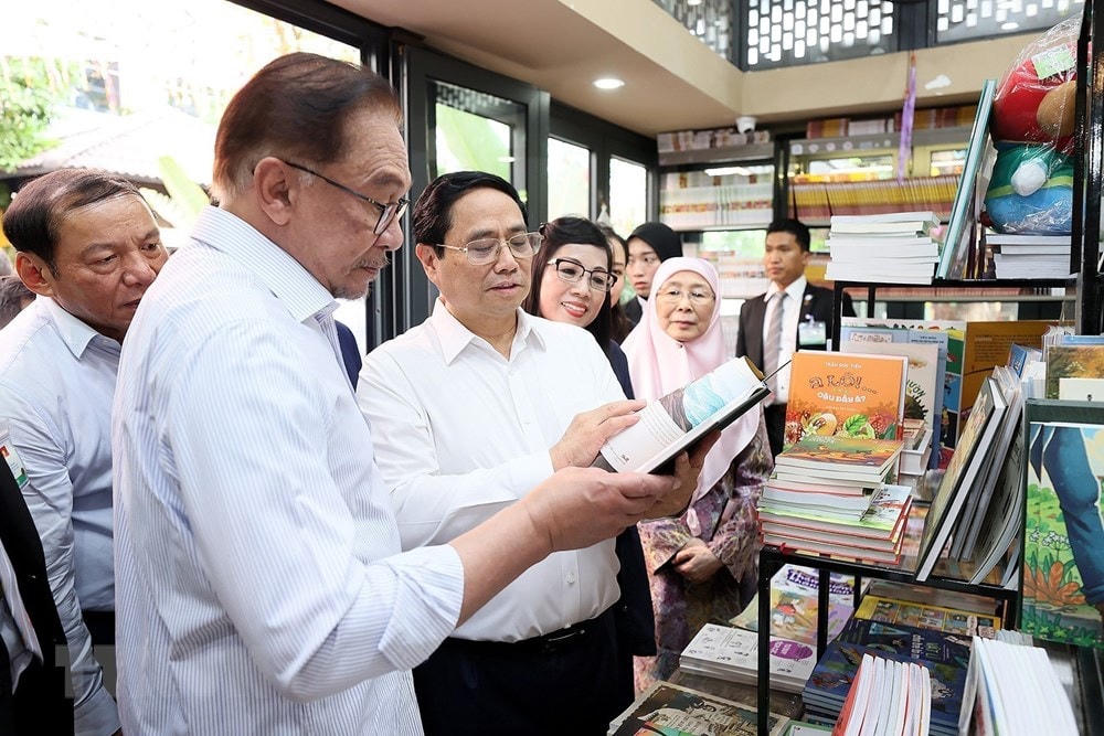 Thủ tướng Phạm Minh Chính và Thủ tướng Malaysia Anwar Ibrahim xem sách tại Phố sách. (Ảnh: Dương Giang/TTXVN).