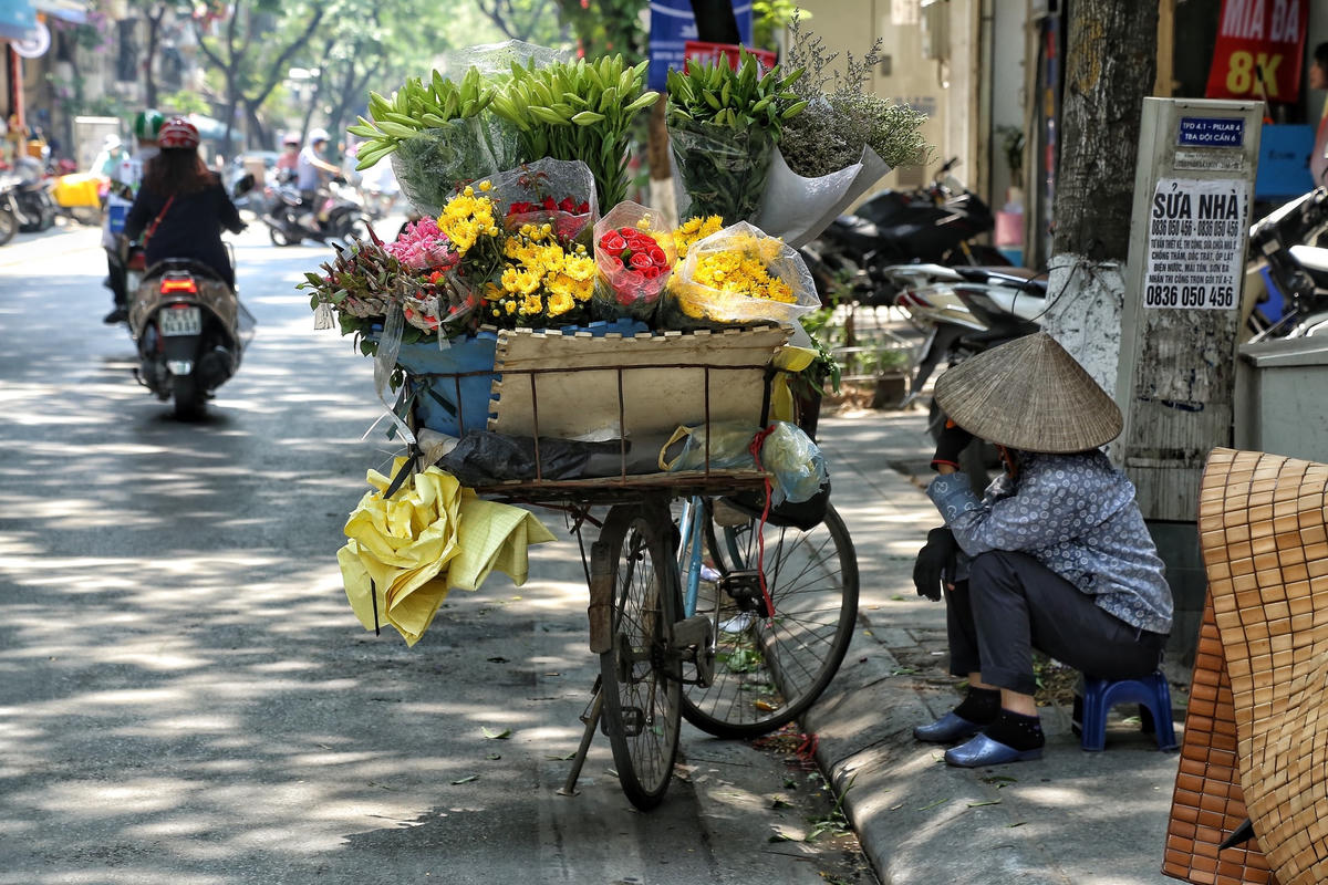 Tại phố Đội Cấn, những người bán hàng rong đều phải tìm nơi có bóng cây để tránh nóng.