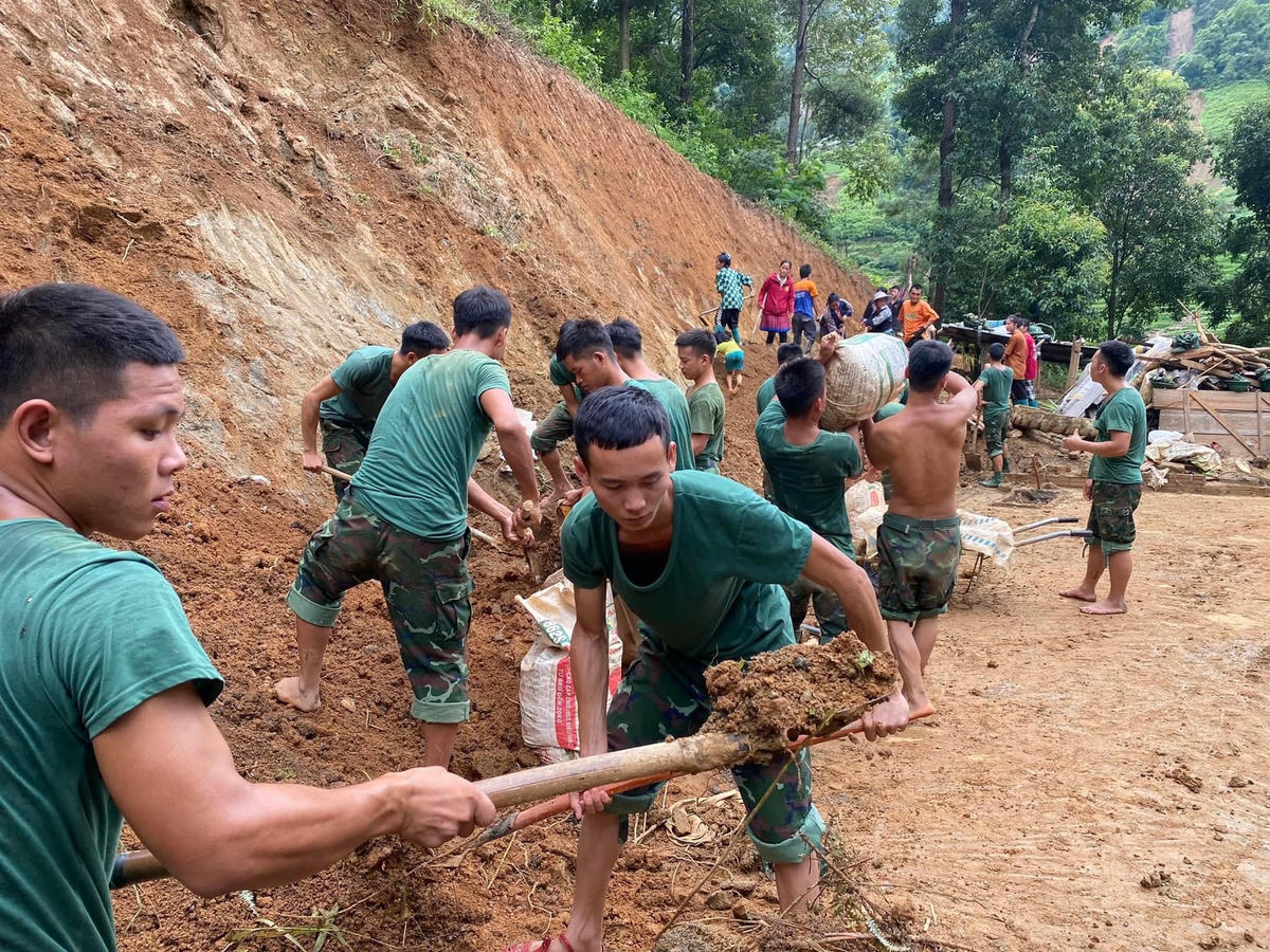 Chiến sĩ Trung đoàn 174 san gạt nền đất làm nhà cho người dân sớm ổn định cuộc sống sau lũ.