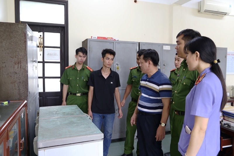 Giang (áo phông đen) sau khi bị tạm giữ hình sự.