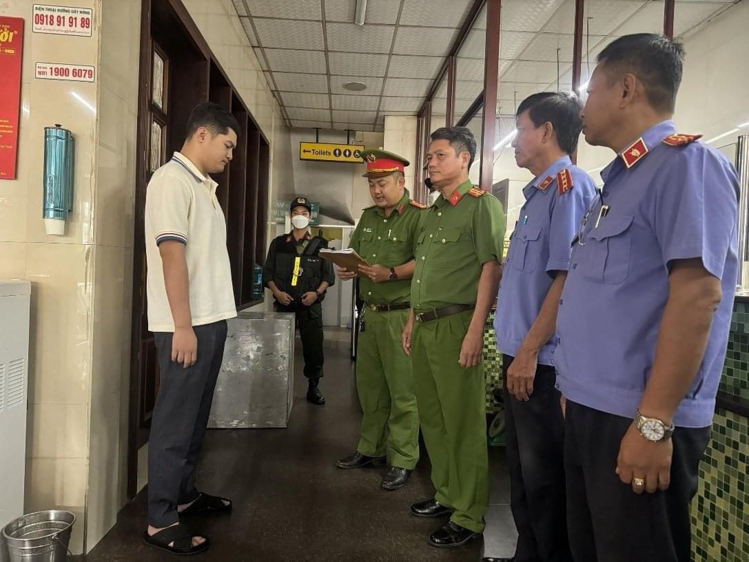 Bị can Lê Dương nghe Công an đọc lệnh khởi tố bị can - Ảnh: CA