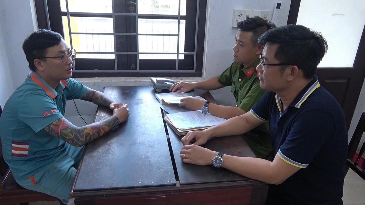 Đối tượng Nguyễn Đức Tài (bìa trái) tại cơ quan Công an.