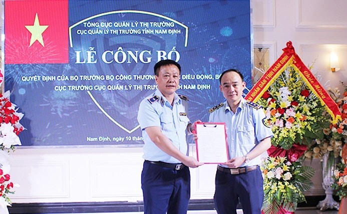 Phó Tổng cục trưởng Tổng cục QLTT Hoàng Ánh Dương (trái) trao quyết định bổ nhiệm của Bộ trưởng Bộ Công Thương tới ông Lê Quang Tú.