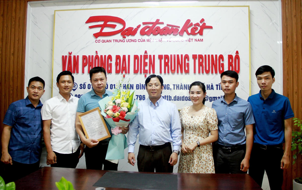 Quyền Tổng Biên tập Báo Đại Đoàn Kết Lê Anh Đạt trao quyết định cho ông Hồ Xuân Hoàng và chụp ảnh kỷ niệm cùng cán bộ, nhân viên Văn phòng đại diện Trung Trung Bộ.