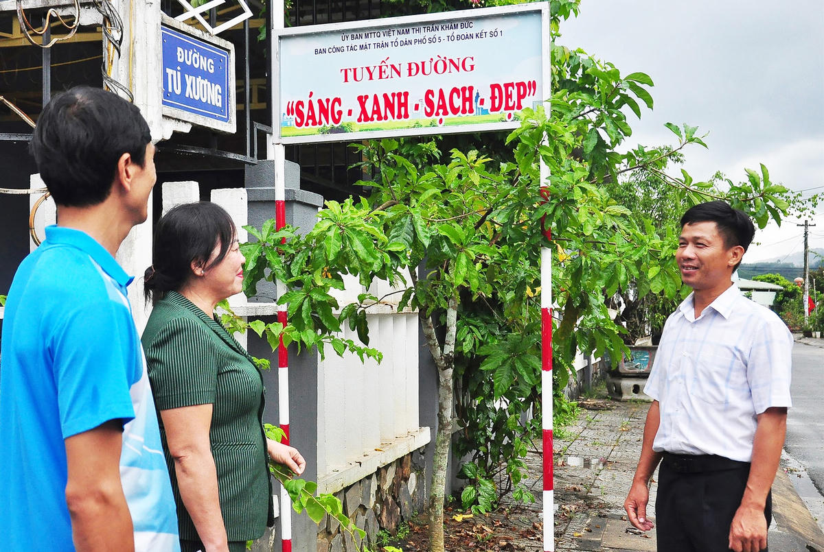 Ông Ngô Bá Lâm (ngoài cùng bên phải) phổ biến mô hình tuyến đường “sáng - xanh - sạch - đẹp” đến người dân thị trấn Khâm Đức.